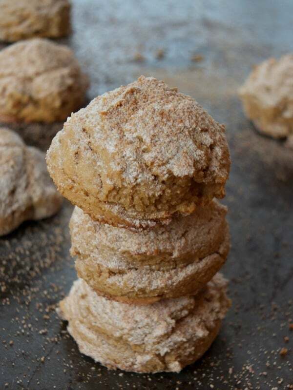 gluten free snowball cookies stacked on top of each other on a baking sheet. 