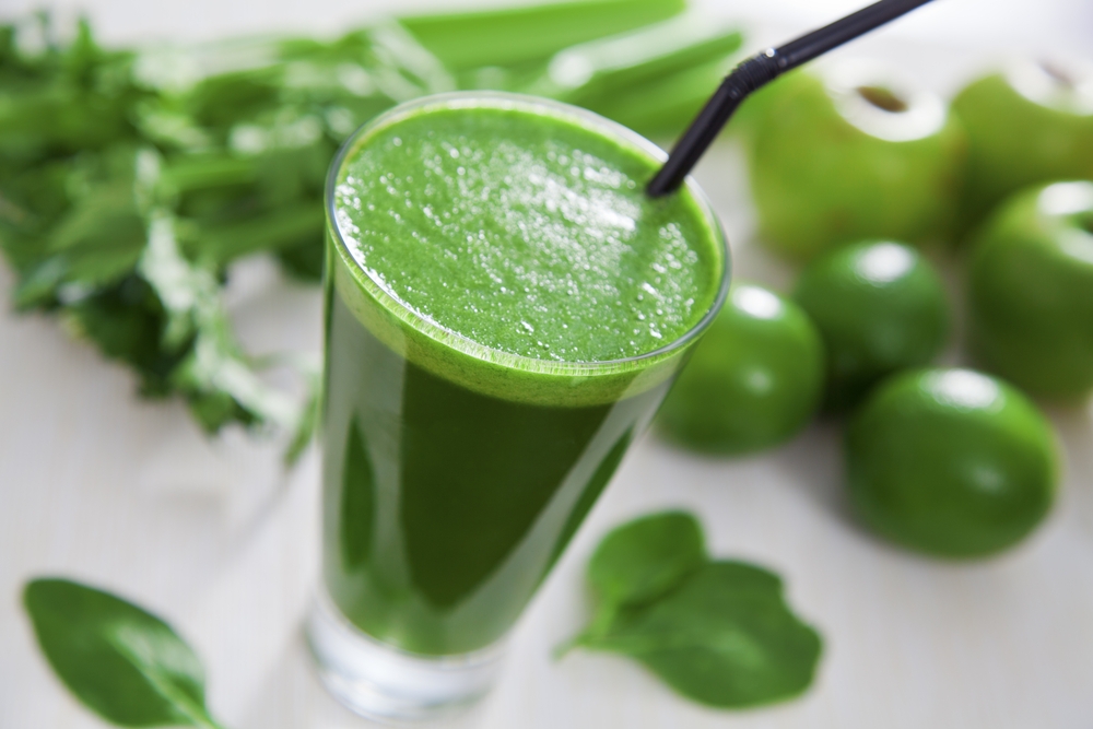 Best Juicer for Celery Kelly Bejelly Fresh celery juice just processed with a juicer for celery. Celery juice in a glass with apples, limes, and celery in the background.