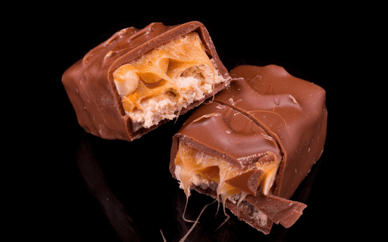 How to Make 15 Paleo Halloween Candy Recipes That Are Scary Good Kelly Bejelly Close-up image: Paleo Snickers bars presented on a sleek black surface.