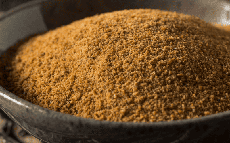 Best Substitute for Honey: 9 Alternatives to Sweeten Your Recipes Kelly Bejelly An overhead view of a rustic ceramic bowl filled with golden-brown raw sugar crystals. The coarse sugar crystals glisten in the light, creating a natural and inviting texture.