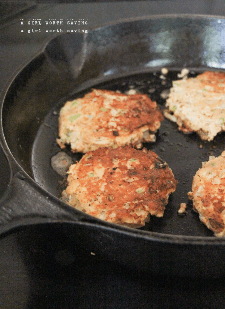 Keto Salmon Cakes Kelly Bejelly keto salmon cakes frying in a cast iron pan