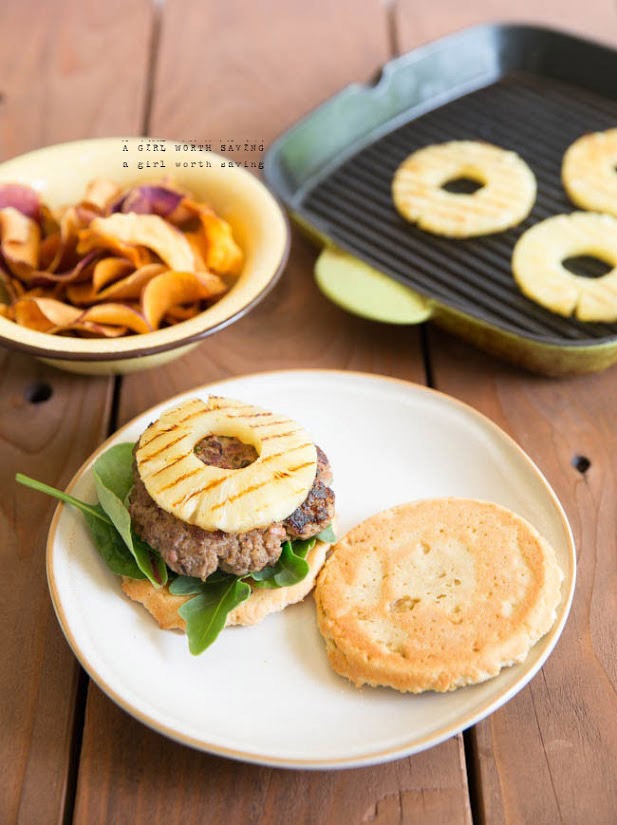 A Hawaiian burger on a plate with grilled pineapple on the background 