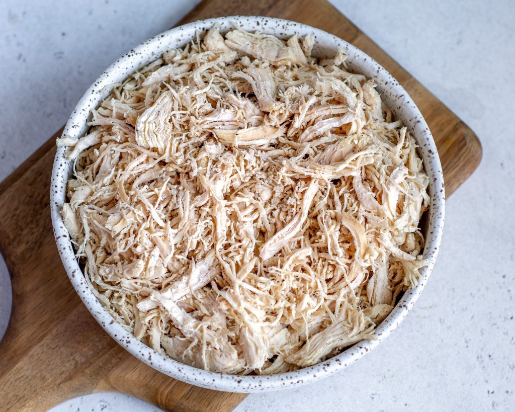 chicken cooked in an instant pot that has been shredded and is placed in a white bowl