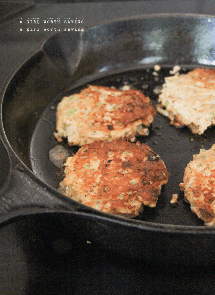 keto salmon cakes frying in a cast iron pan