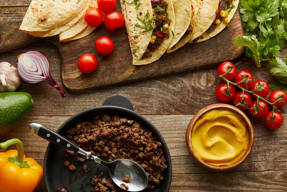Slow Cooker Taco Meat Kelly Bejelly slow cooker taco meat in a bowl with tomatoes, onion, corn tortillas and avocado beside it.