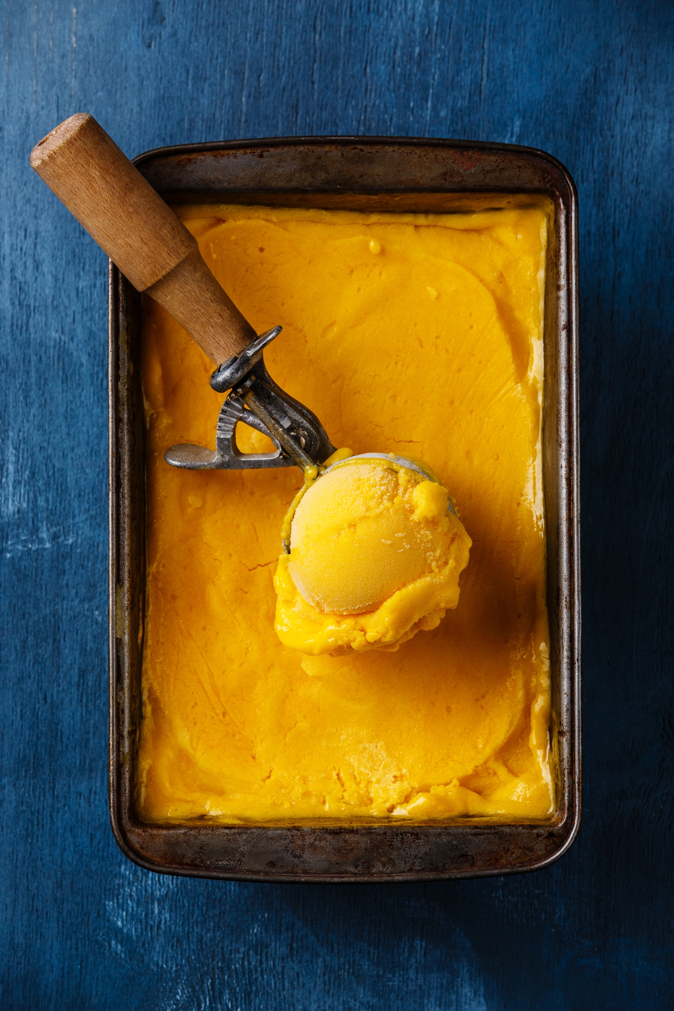 Recipe Index Kelly Bejelly mango ice cream ball in scoop on blue background