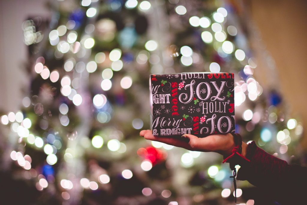 12 Days of Christmas Gifts Kelly Bejelly Picture of a Christmas Present in front of Christmas tree for the 12 days of Christmas