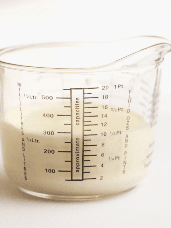 How Many Ounces in a Cup? Kelly Bejelly measuring cup with milk inside.