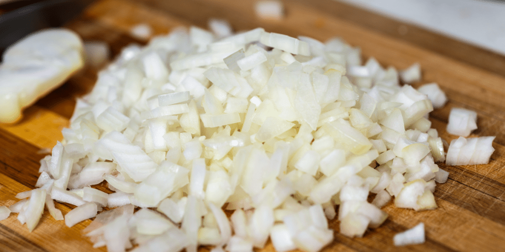 Slow Cooker Taco Meat Kelly Bejelly diced onions on a cutting board for slow cooker taco meat