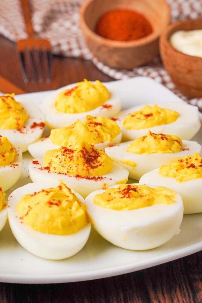 Keto Deviled Eggs Kelly Bejelly Close up of a plate of keto deviled eggs with spices in the background