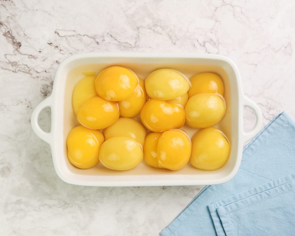 Easy Peach Cobbler with Cake Mix Kelly Bejelly canned peaches in a casserole dish
