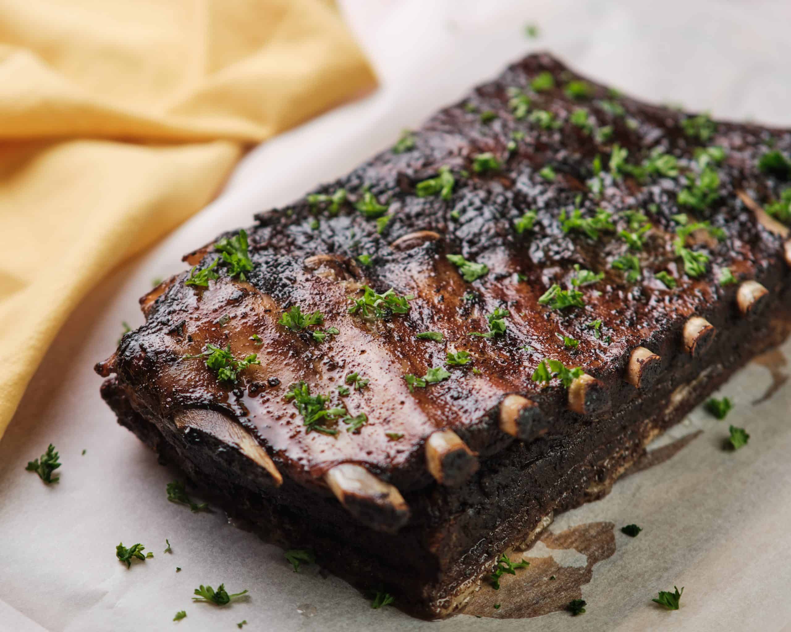 Recipe Index Kelly Bejelly spork spare ribs on a piece of butcher block paper with herbs on top