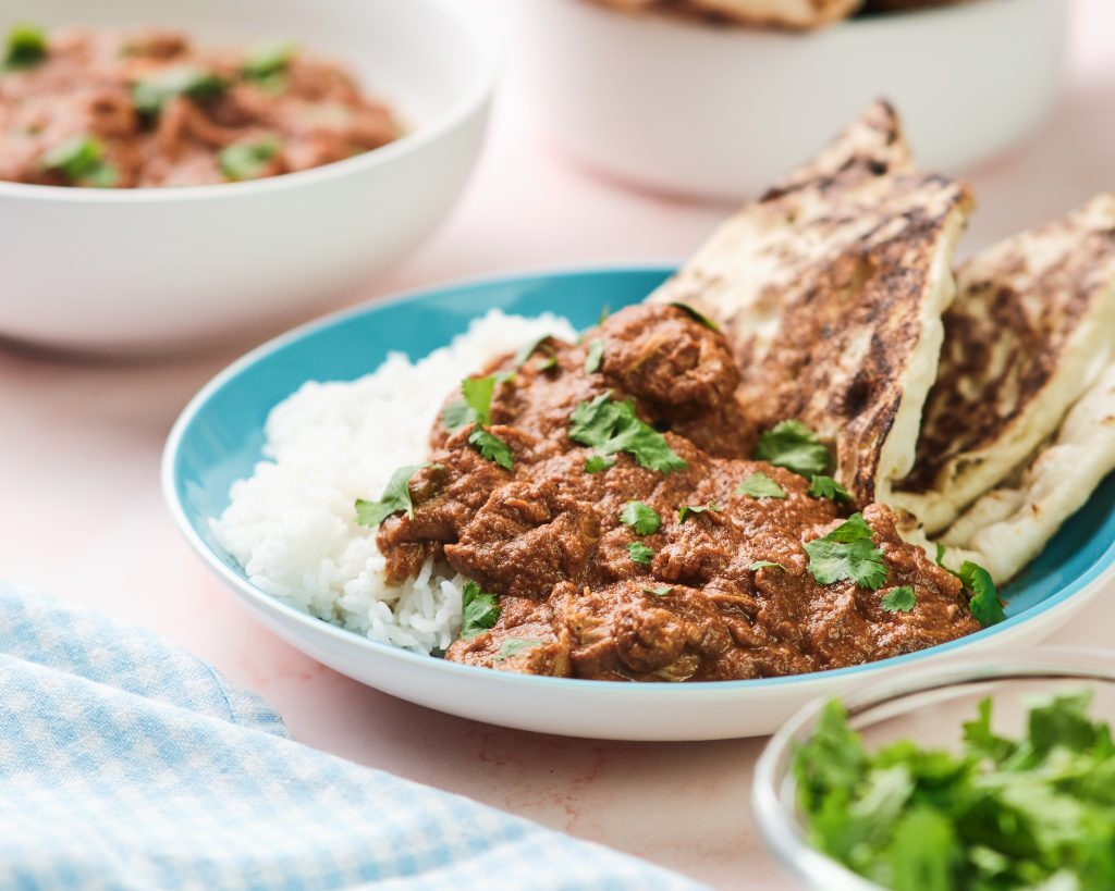 Slow Cooker Chicken Tikka Masala Kelly Bejelly chicken tikka masala with rice and naan on a blue plate