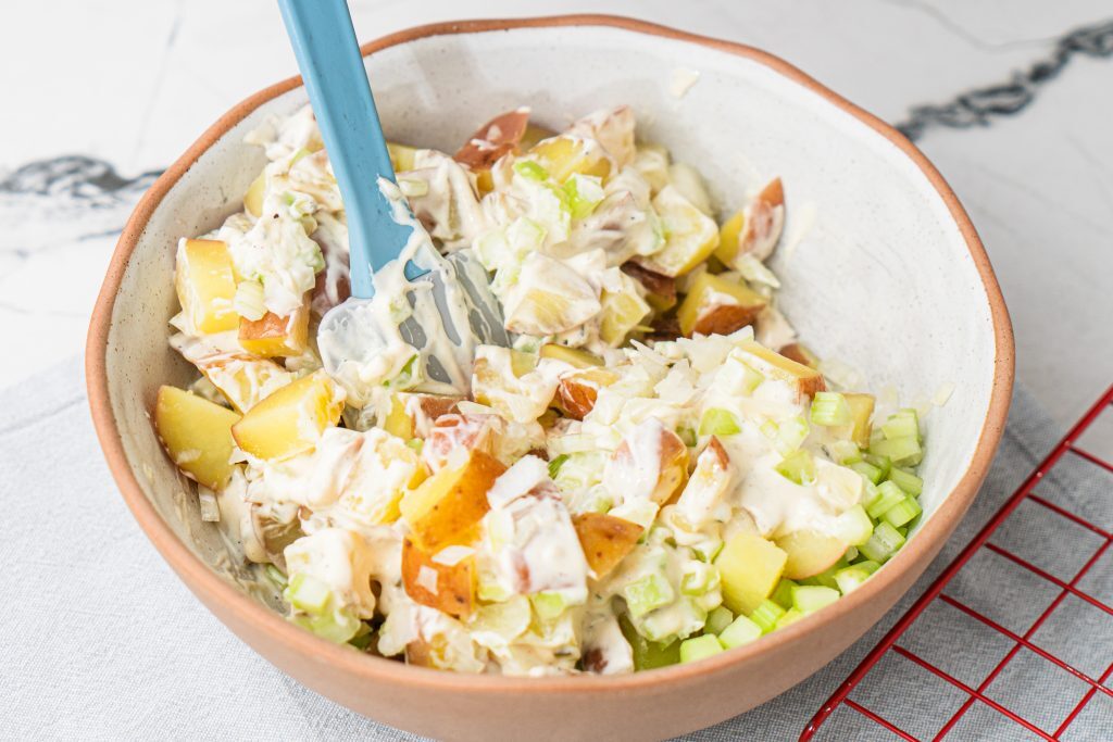 Red Potato Salad Recipe: A Refreshing Explosion of Flavors! Kelly Bejelly mixing mayo mixture with cooked red potatoes