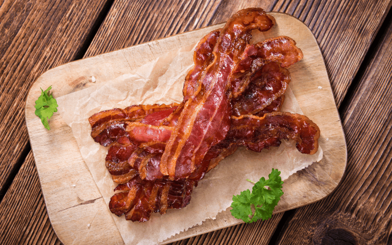 The Ultimate Guide: How Long Can Cooked Bacon Sit Out Before It Spoils? Kelly Bejelly top view of cooked bacon on cutting board