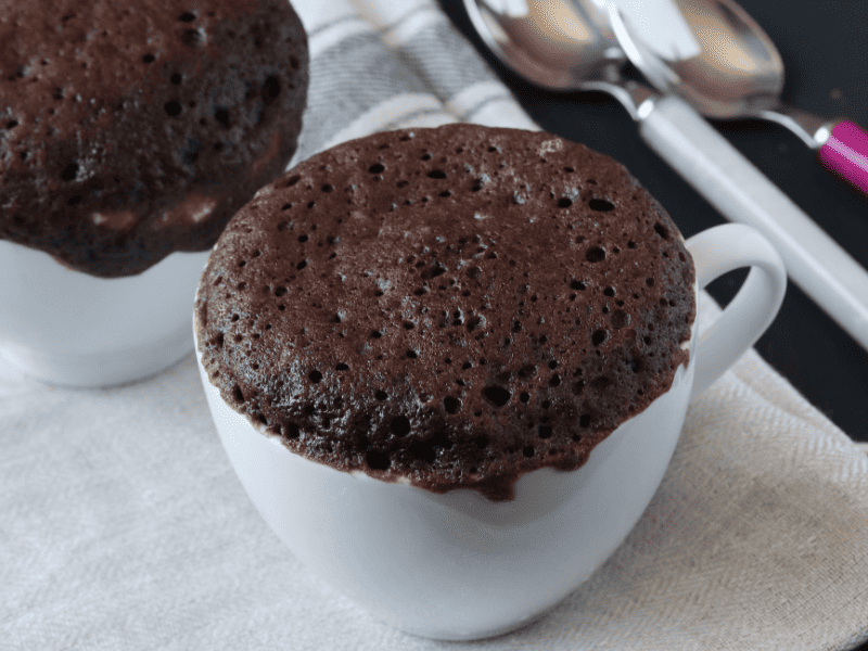 Recipe Index Kelly Bejelly Chocolate protein mug cake on a counter with spoons in the back ground