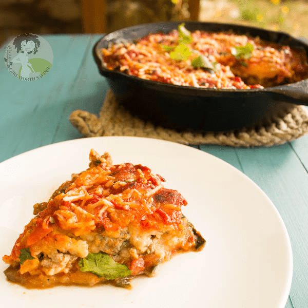 Pizza Casserole (Low Carb) Kelly Bejelly low carb pizza casserole on a plate with a cast iron pan in the background.